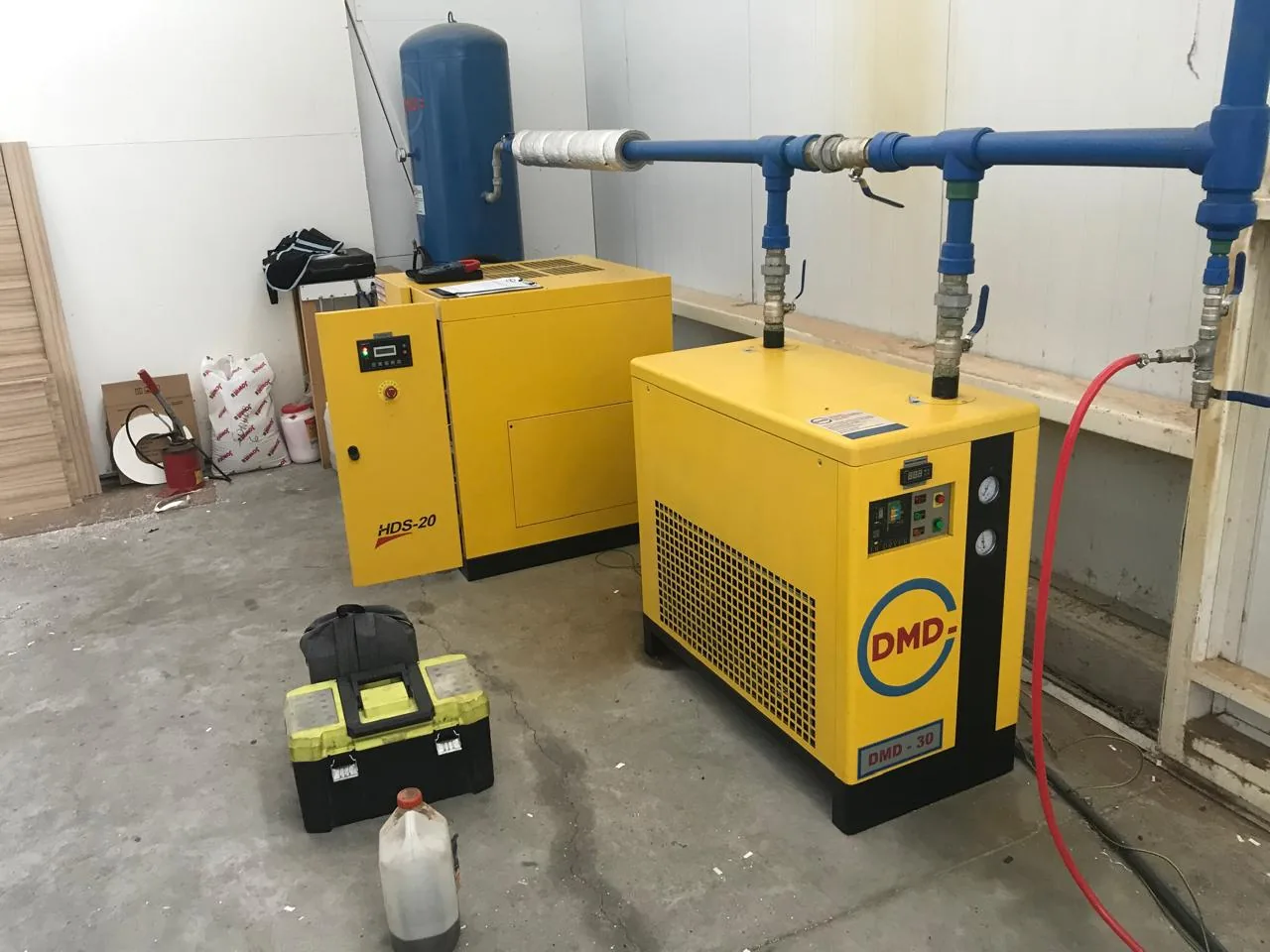 Instalación de compresores DMD y cañerías de aire comprimido en sala industrial.